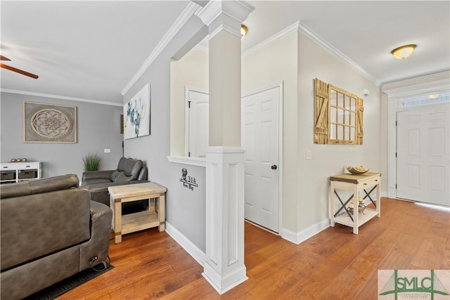 living room with hardwood / wood-style floors, decorative columns, ceiling fan, and crown molding