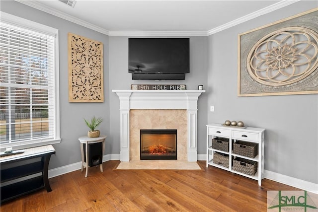 interior space with hardwood / wood-style floors, ornamental molding, and a high end fireplace