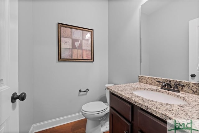 bathroom featuring wood-type flooring, vanity, and toilet