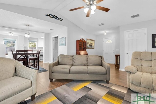 living room featuring vaulted ceiling with beams, ceiling fan, and dark wood-type flooring