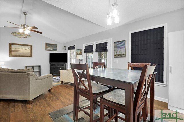 dining area with ceiling fan, wood-type flooring, and lofted ceiling