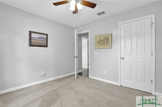 unfurnished bedroom featuring ceiling fan and light carpet