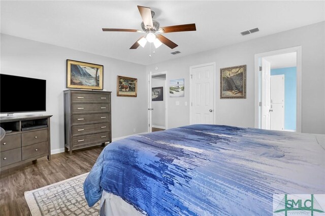 bedroom with dark hardwood / wood-style flooring and ceiling fan