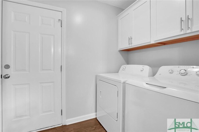 laundry room featuring cabinets, washer and clothes dryer, and dark wood-type flooring