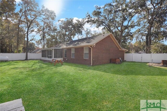 back of house featuring a yard and a sunroom