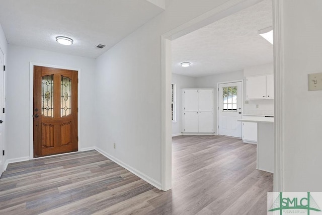 entrance foyer featuring a textured ceiling and light hardwood / wood-style floors