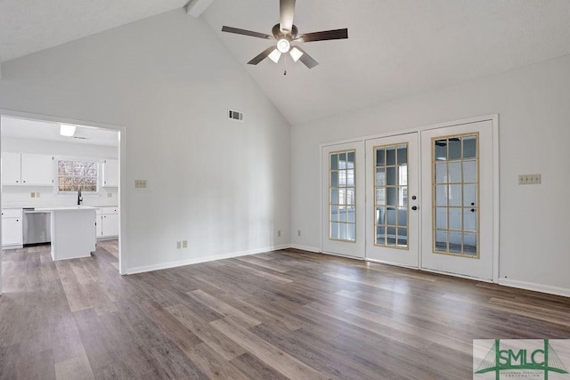 unfurnished living room with beam ceiling, light hardwood / wood-style flooring, high vaulted ceiling, and french doors