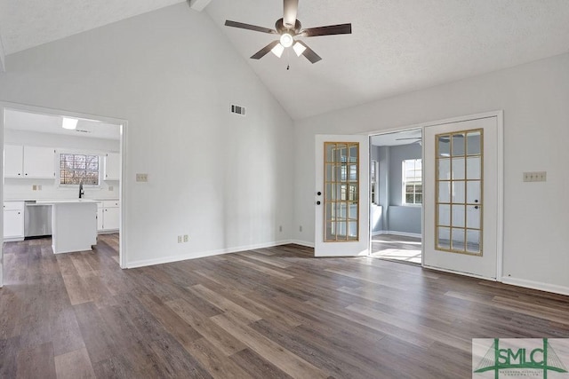 unfurnished living room with french doors, a textured ceiling, dark hardwood / wood-style floors, and high vaulted ceiling