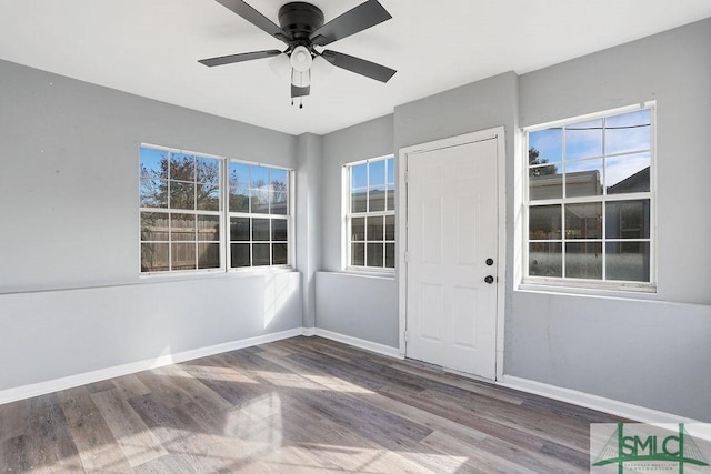 unfurnished sunroom with ceiling fan