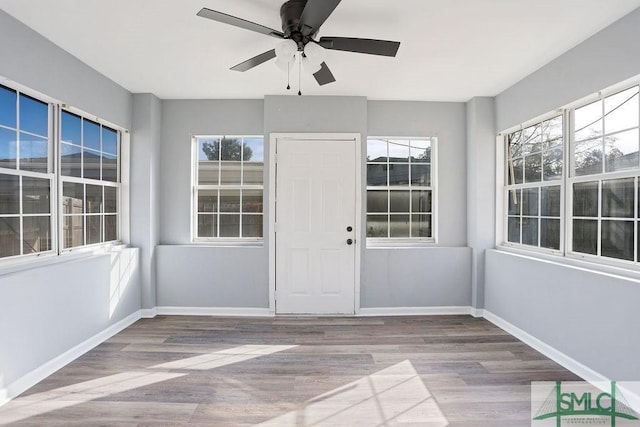 unfurnished sunroom featuring ceiling fan