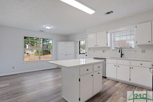 kitchen featuring dishwasher, a kitchen island, a wealth of natural light, and sink