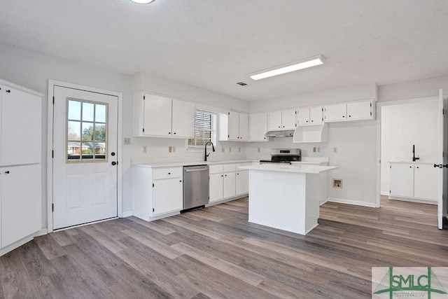 kitchen with a wealth of natural light, light hardwood / wood-style floors, white cabinetry, and appliances with stainless steel finishes