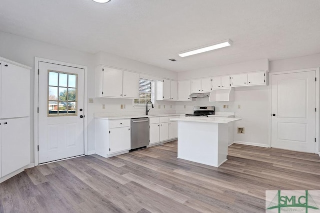 kitchen featuring a healthy amount of sunlight, light wood-type flooring, white cabinetry, and appliances with stainless steel finishes