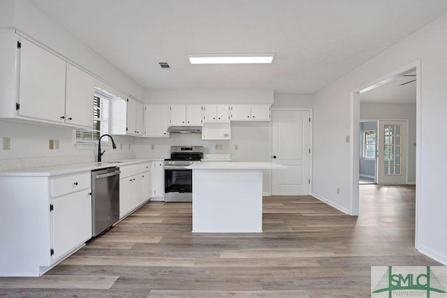 kitchen with a center island, light wood-type flooring, white cabinetry, and stainless steel appliances