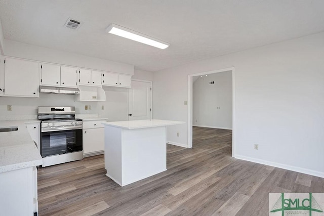 kitchen with white cabinets, a kitchen island, stainless steel stove, and light hardwood / wood-style flooring