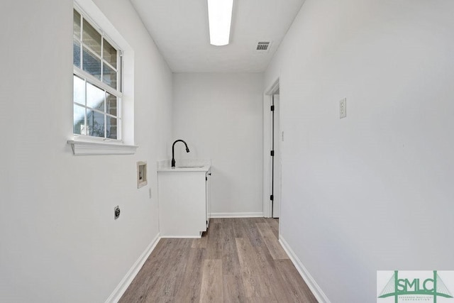 laundry room with sink, cabinets, electric dryer hookup, hookup for a washing machine, and light wood-type flooring