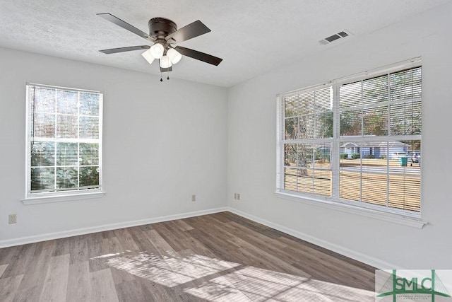 spare room with a textured ceiling, hardwood / wood-style flooring, and ceiling fan