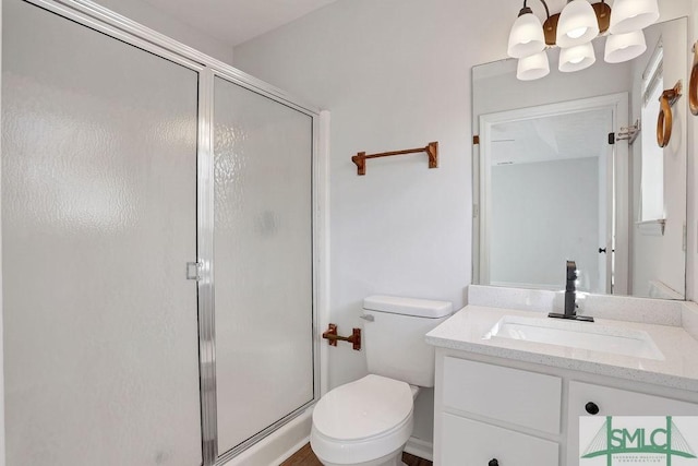 bathroom featuring toilet, vanity, and walk in shower