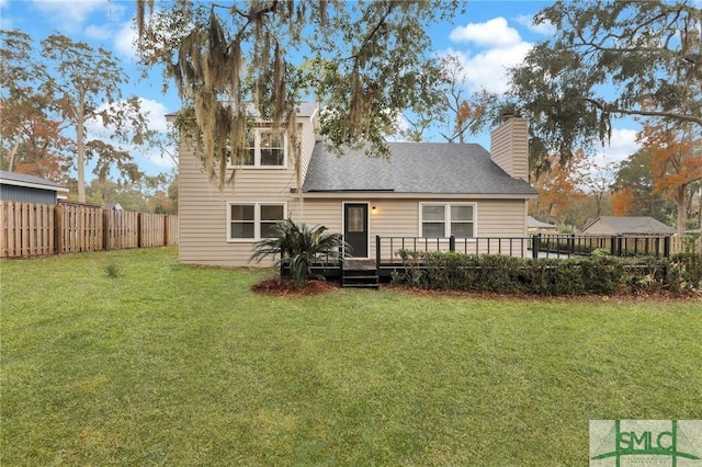 rear view of property with a yard and a wooden deck