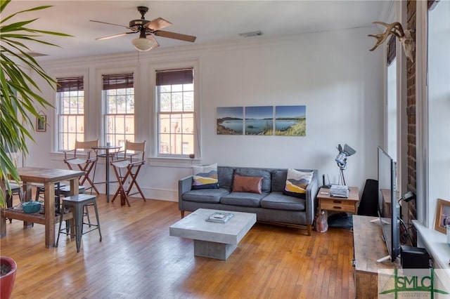 living room with ceiling fan, light hardwood / wood-style flooring, and ornamental molding