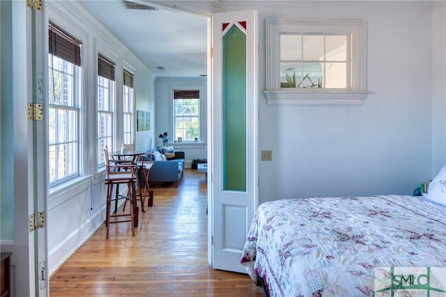 bedroom with hardwood / wood-style floors and ornamental molding