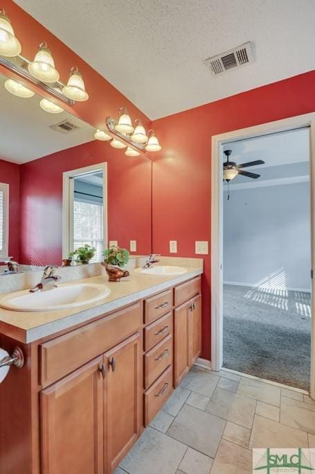 bathroom with ceiling fan, a textured ceiling, and vanity