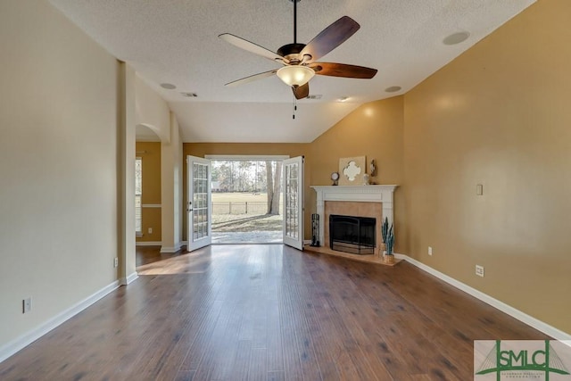 unfurnished living room featuring dark hardwood / wood-style flooring, a textured ceiling, vaulted ceiling, and ceiling fan