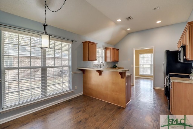 kitchen with kitchen peninsula, a kitchen breakfast bar, dark hardwood / wood-style flooring, vaulted ceiling, and decorative light fixtures