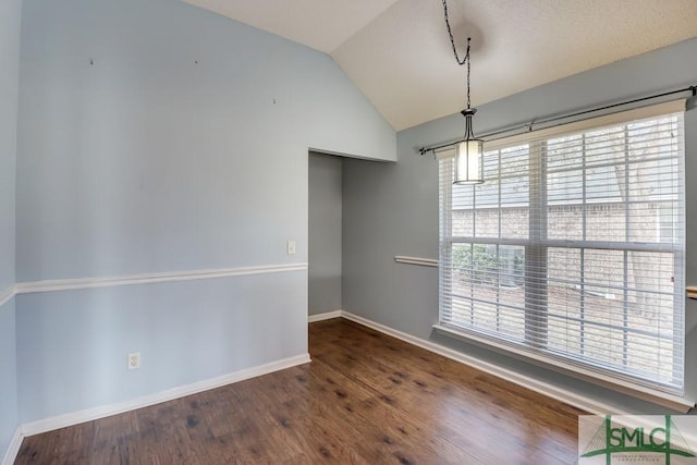 unfurnished room featuring dark hardwood / wood-style flooring, vaulted ceiling, and plenty of natural light