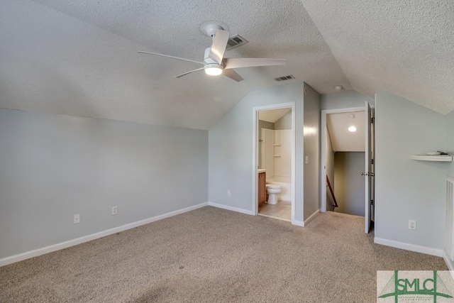 bonus room featuring a textured ceiling, light colored carpet, vaulted ceiling, and ceiling fan