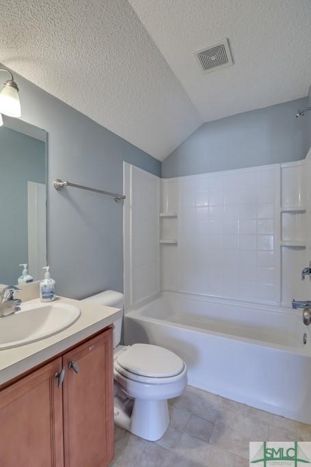 full bathroom with vanity, shower / bathtub combination, a textured ceiling, and vaulted ceiling