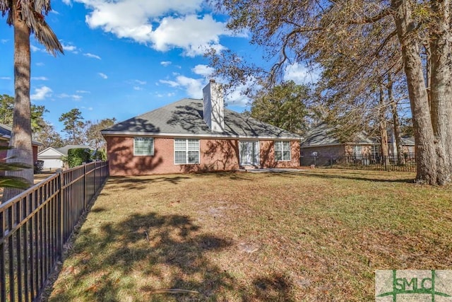 rear view of house featuring a yard