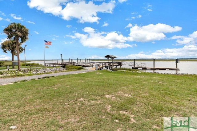 view of yard with a boat dock and a water view