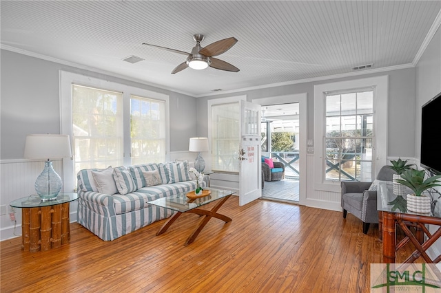 living room featuring hardwood / wood-style floors, ceiling fan, ornamental molding, and a wealth of natural light