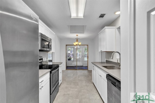 kitchen featuring pendant lighting, white cabinets, sink, a notable chandelier, and stainless steel appliances