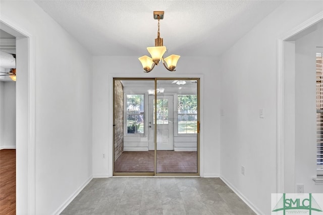 interior space with a textured ceiling, french doors, and ceiling fan with notable chandelier