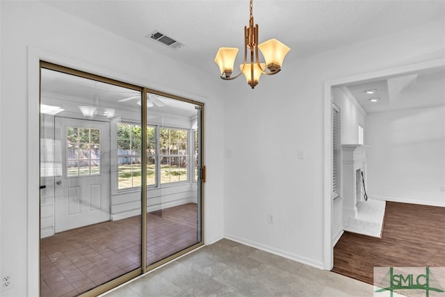 interior space with light wood-type flooring, a textured ceiling, and an inviting chandelier