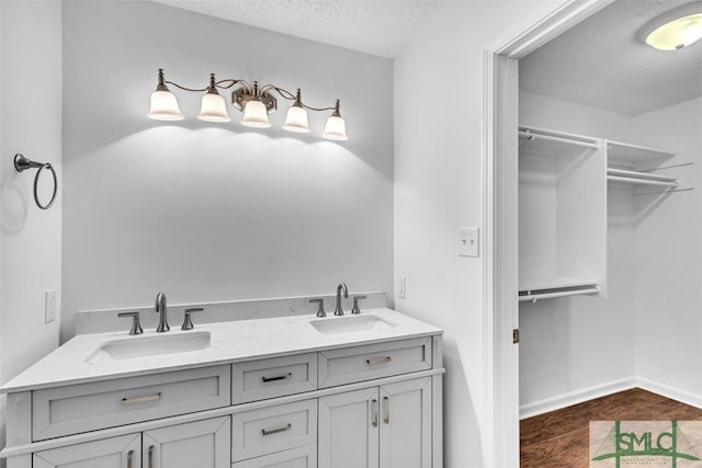 bathroom featuring hardwood / wood-style floors, vanity, and a textured ceiling