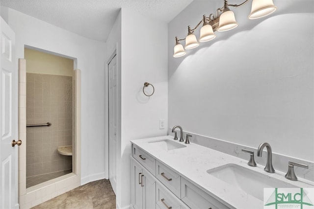 bathroom featuring vanity, tiled shower, and a textured ceiling