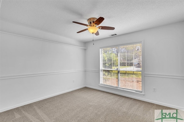 unfurnished room with ceiling fan, carpet floors, and a textured ceiling