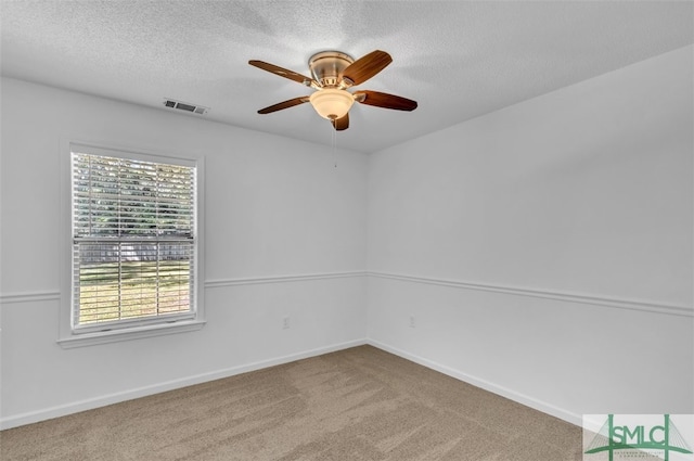 carpeted spare room with ceiling fan and a textured ceiling