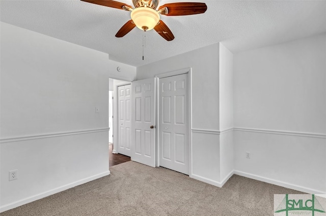 unfurnished bedroom featuring carpet flooring, ceiling fan, and a textured ceiling