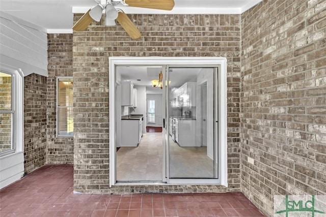 view of exterior entry with ceiling fan and sink