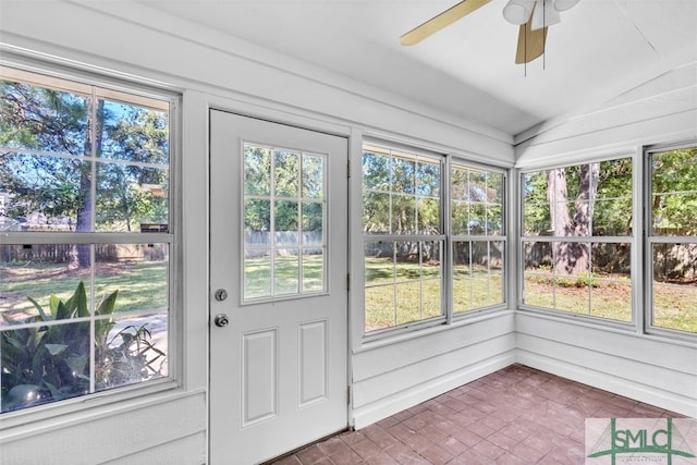 unfurnished sunroom with ceiling fan, a healthy amount of sunlight, and lofted ceiling