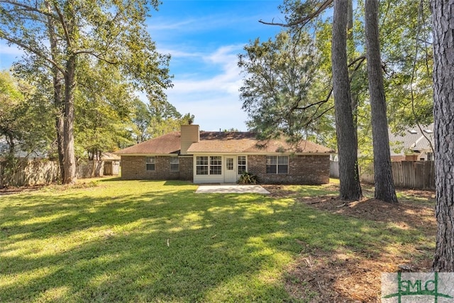 rear view of house with a yard and a patio area