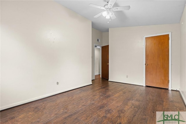 empty room featuring ceiling fan, dark wood-type flooring, and vaulted ceiling