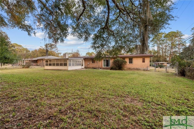 exterior space featuring a sunroom and a yard