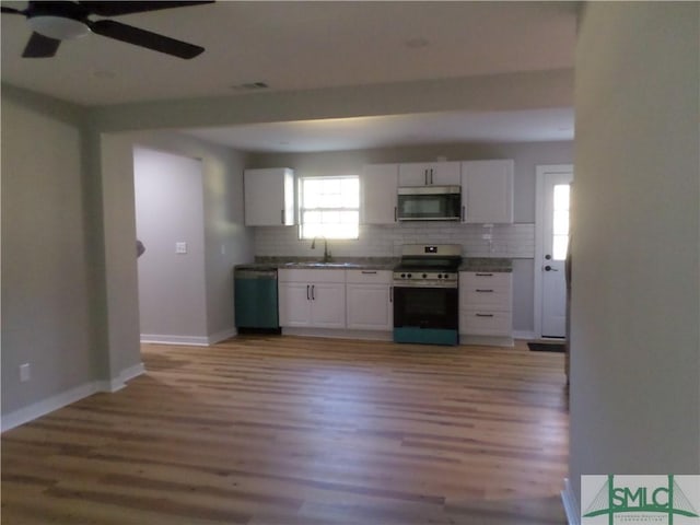 kitchen with white cabinetry, sink, appliances with stainless steel finishes, and light hardwood / wood-style flooring