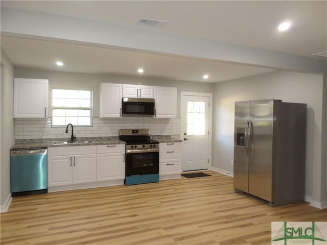 kitchen featuring white cabinets, plenty of natural light, sink, and stainless steel appliances