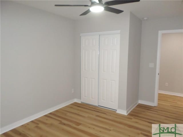 unfurnished bedroom featuring ceiling fan, a closet, and light wood-type flooring